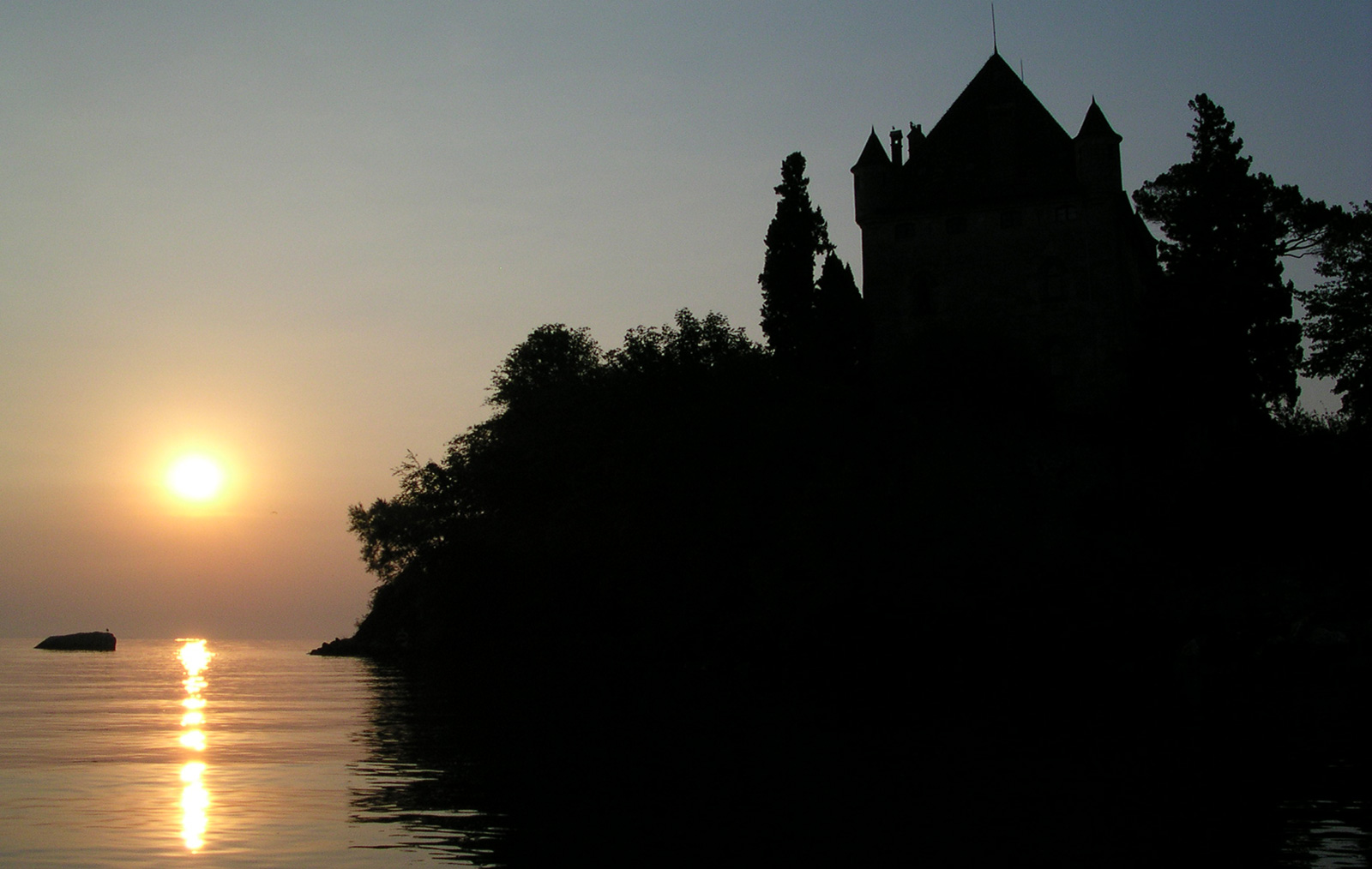 Yvoire castle during sunrise over Lake Geneva.